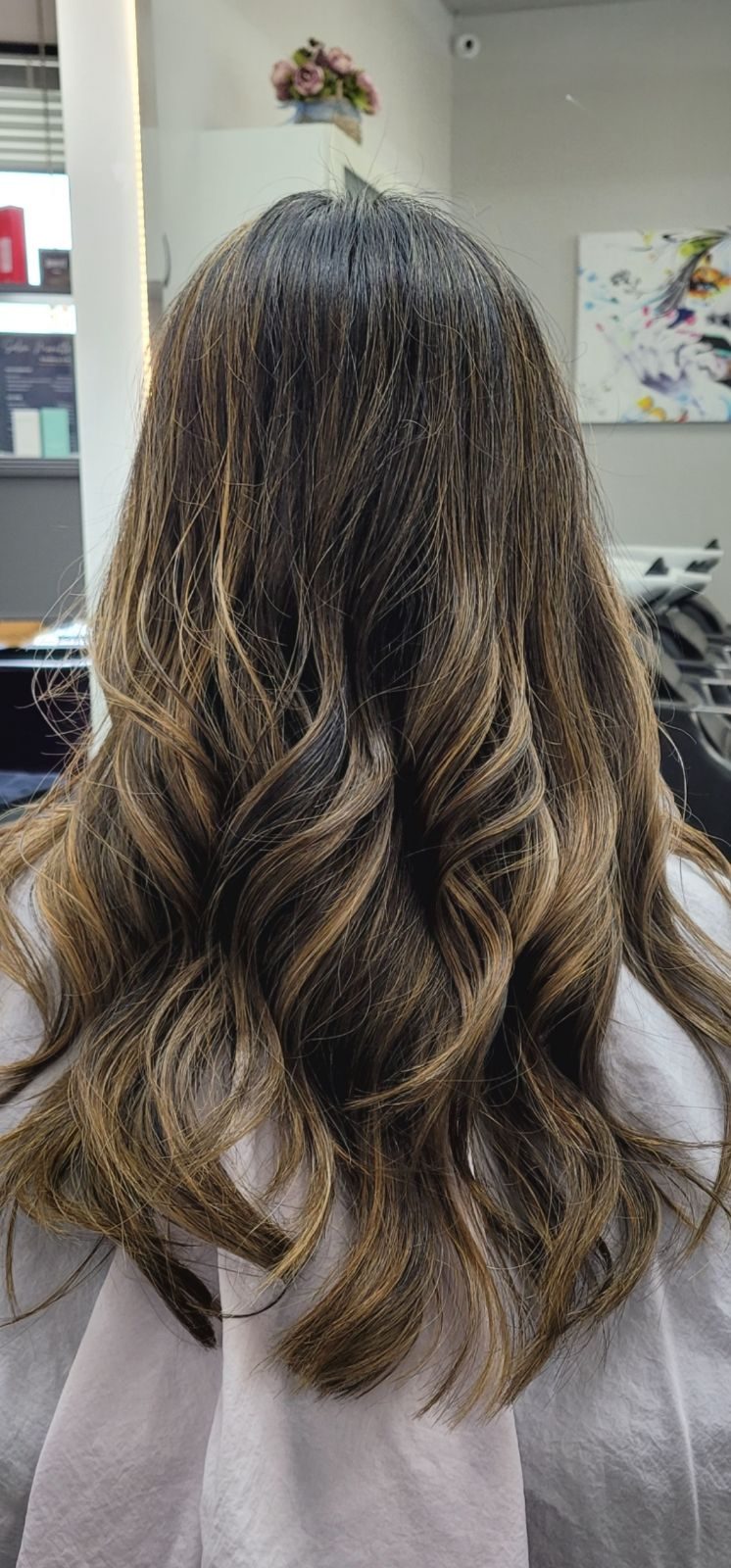 Long dark hair with golden balayage in soft waves