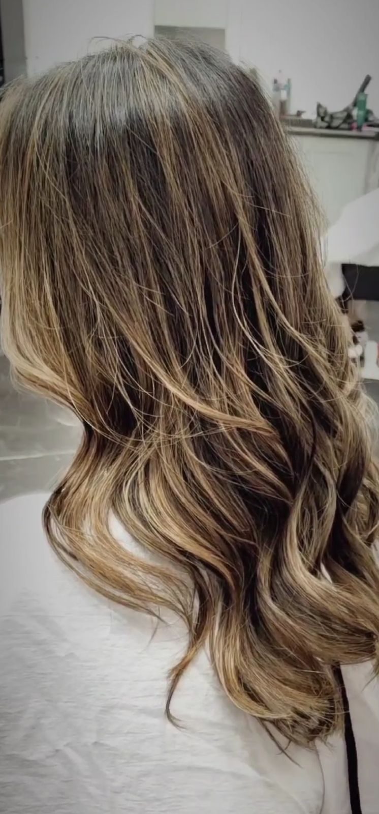 Back view of long wavy hair with honey-blonde balayage