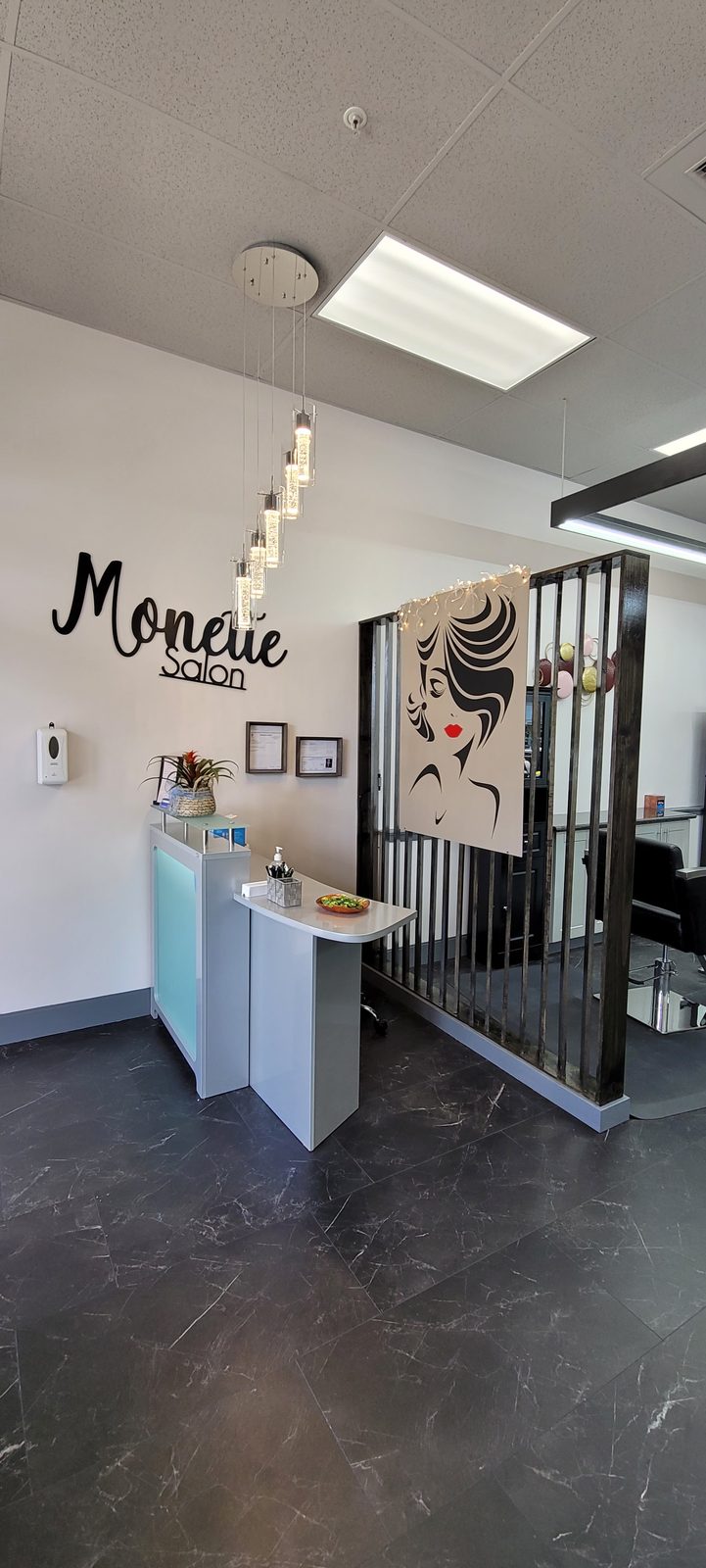 Reception inside Salon Monette, with the Monette Salon wall sign above the front desk